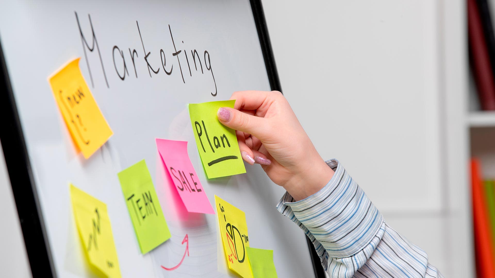 Trabajadora de consultora de marketing preparando tablero de marketing con etiquetas
